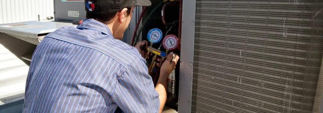 HVAC technician servicing a condenser unit in Clemson